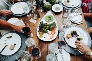 Dinner table filled with empty dishes and wine glasses